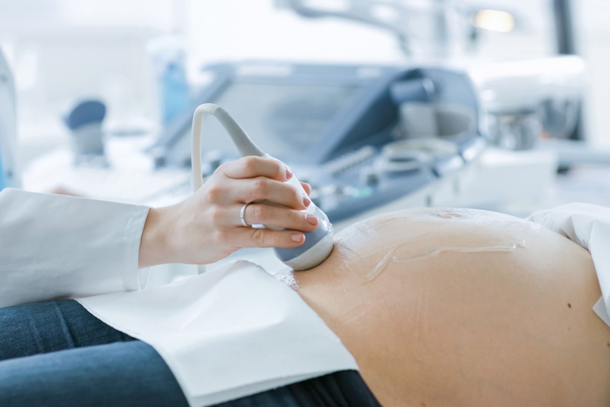 Doctora realizando una ecografía a mujer embarazada tumbada.